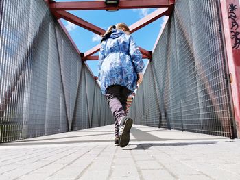 Rear view of woman standing on footbridge