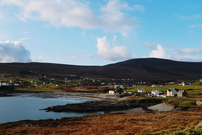 Scenic view of lake by buildings against sky