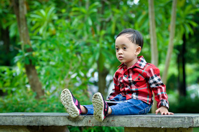 Cute boy looking away sitting outdoors