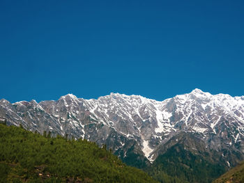 Scenic view of snowcapped mountains against clear blue sky