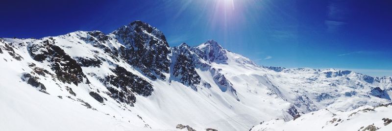 Sun shining through clouds over mountain