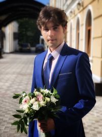 Portrait of man holding flower bouquet