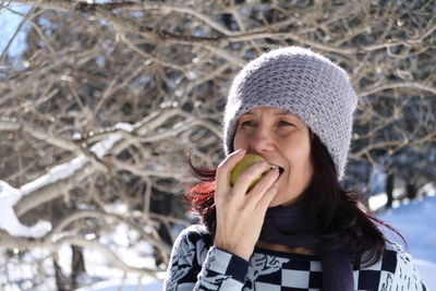 Close-up of smiling mature woman eating fruit