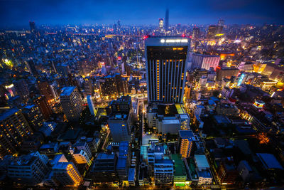 Illuminated cityscape against sky at night