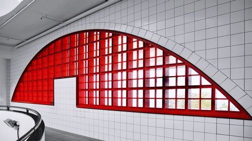 Reflection of illuminated red ceiling on glass of building