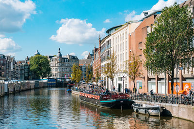 Canal amidst buildings in city against sky