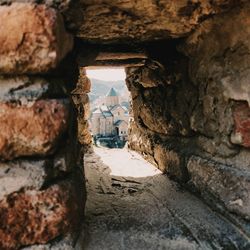 View of old stone wall in alley amidst buildings