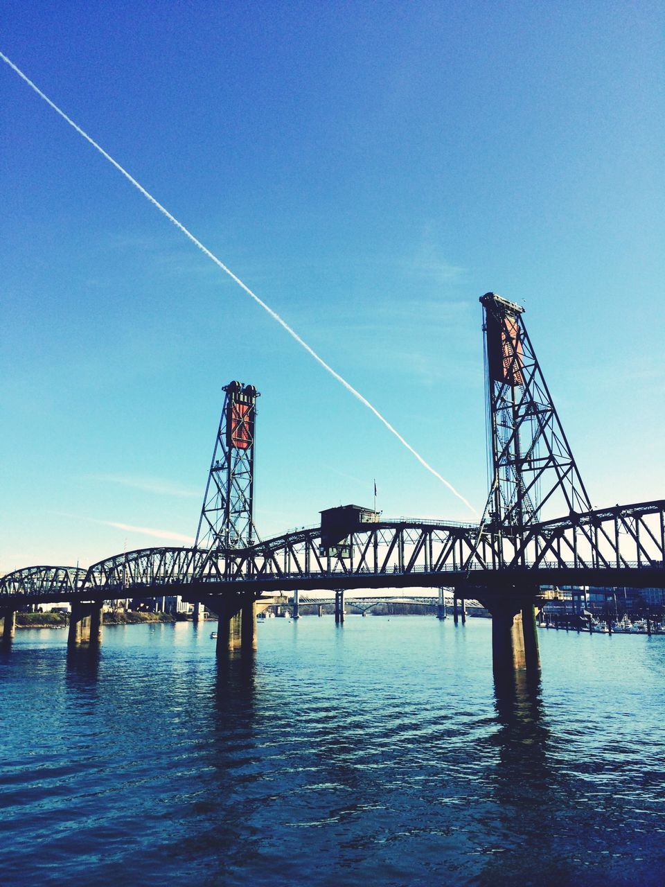 connection, bridge - man made structure, built structure, engineering, water, architecture, blue, suspension bridge, waterfront, sky, low angle view, bridge, transportation, river, clear sky, outdoors, travel destinations, long, no people, copy space