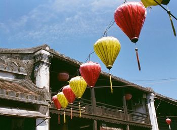 Low angle view of lanterns hanging against building