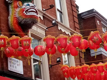 Low angle view of lanterns hanging by building