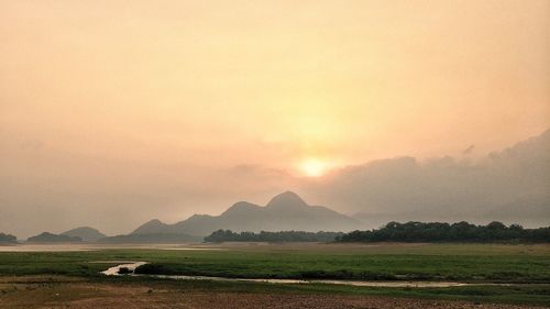 Scenic view of field against sky during sunset