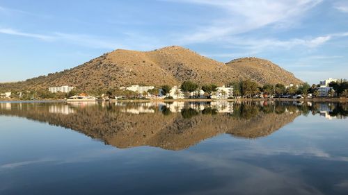 Scenic view of lake by buildings against sky