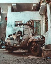 Damaged car on road amidst buildings