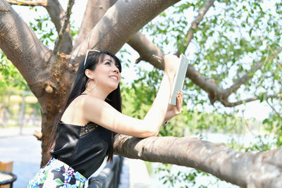 Full length of a young woman against tree