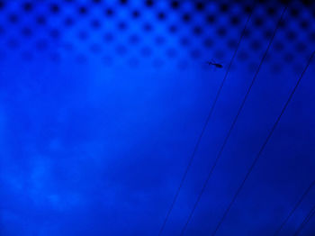 Low angle view of airplane flying against blue sky