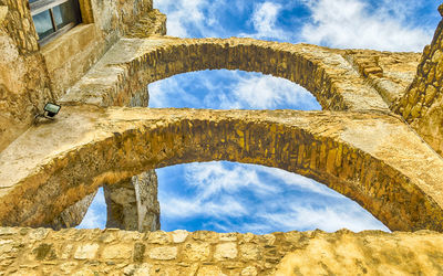 Low angle view of old building against cloudy sky