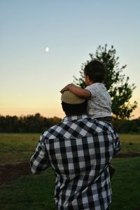 Father holding son observering sunset 