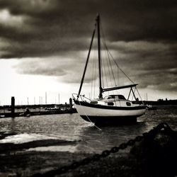 Boats moored in sea at sunset