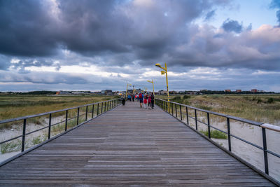 People on walkway against sky