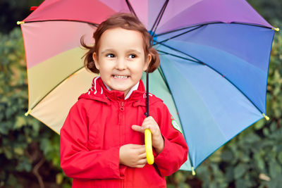 Little child with multicolored rainbow umbrella outdoors