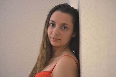 Portrait of young woman leaning on wall