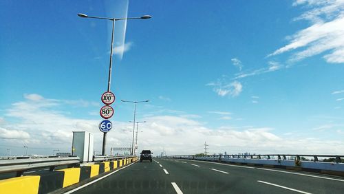 Road sign against sky in city