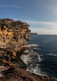 Rock formations by sea against sky