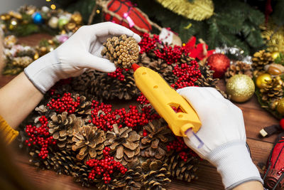 Cropped hand of woman holding christmas tree