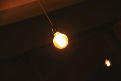 Low angle view of illuminated lamp at night