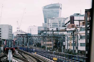 Railroad tracks amidst buildings in city against sky