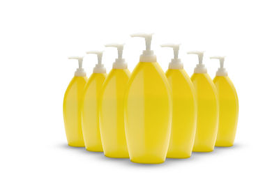 Close-up of yellow bottles against white background