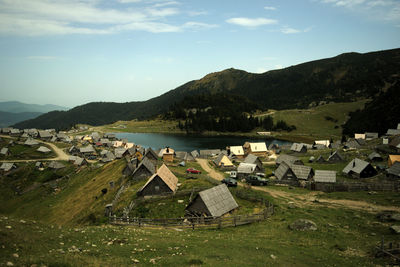 High angle view of houses by lake and buildings against sky