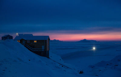 Scenic view of snow covered land against sky during sunset