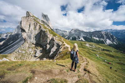 Rear view of man walking on mountain against sky