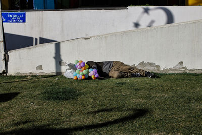Balloon seller man is sleeping among the shadows of turkish flags