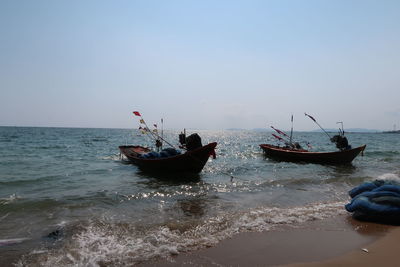 People on beach against clear sky