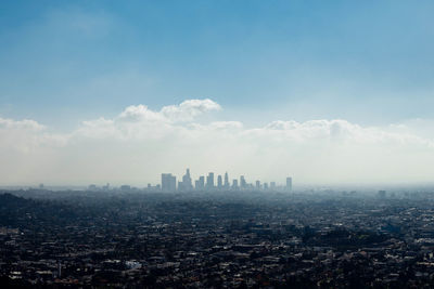 Cityscape against cloudy sky