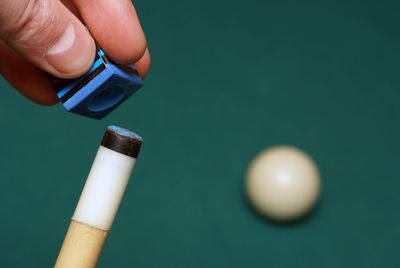 Close-up of hand holding pool cue