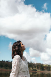 Woman looking away against sky