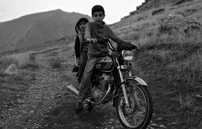 Portrait of man riding motorcycle on field