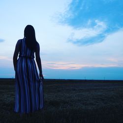 Rear view of woman standing against sky