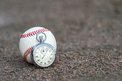 Close-up of ball and stopwatch on the ground