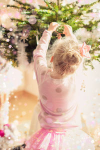 Rear view of ballet dancer decorating christmas tree