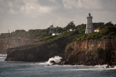 View of lighthouse by sea against sky