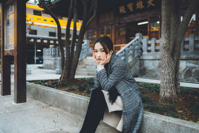 Portrait of woman sitting in snow