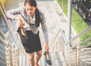 Woman with umbrella walking on steps