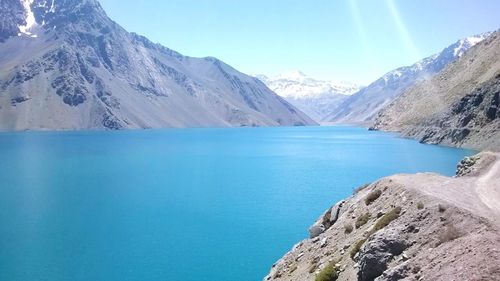 Scenic view of lake and mountains against blue sky