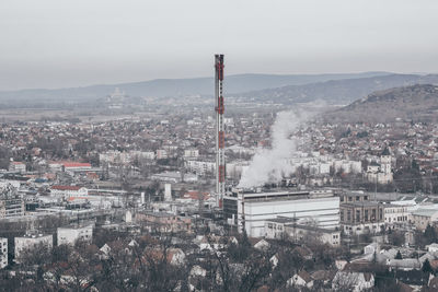 Smoke emitting from factory against clear sky