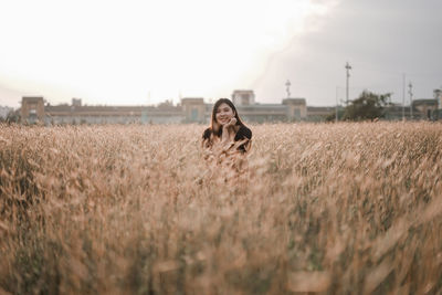 Young woman looking away standing in field