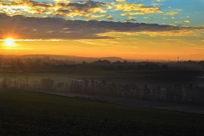 Scenic view of field against sky during sunset